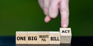 Hand turning "One Big Beautiful Bill Act" cubes, image source: Shutterstock