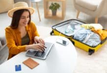 Happy young woman planning vacation travel with laptop, source: Shutterstock