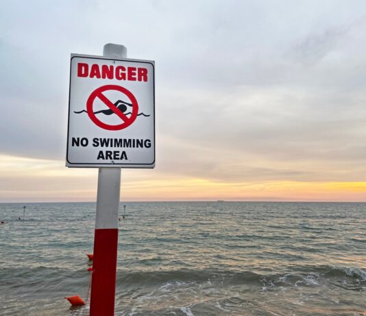"No swimming" beach sign, source: Shutterstock