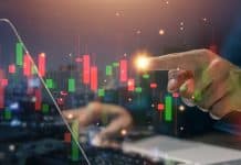 Hand at stockmarket chart, source: Shutterstock