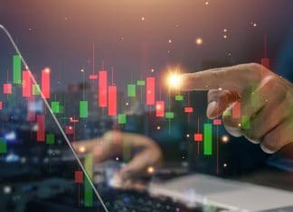 Hand at stockmarket chart, source: Shutterstock