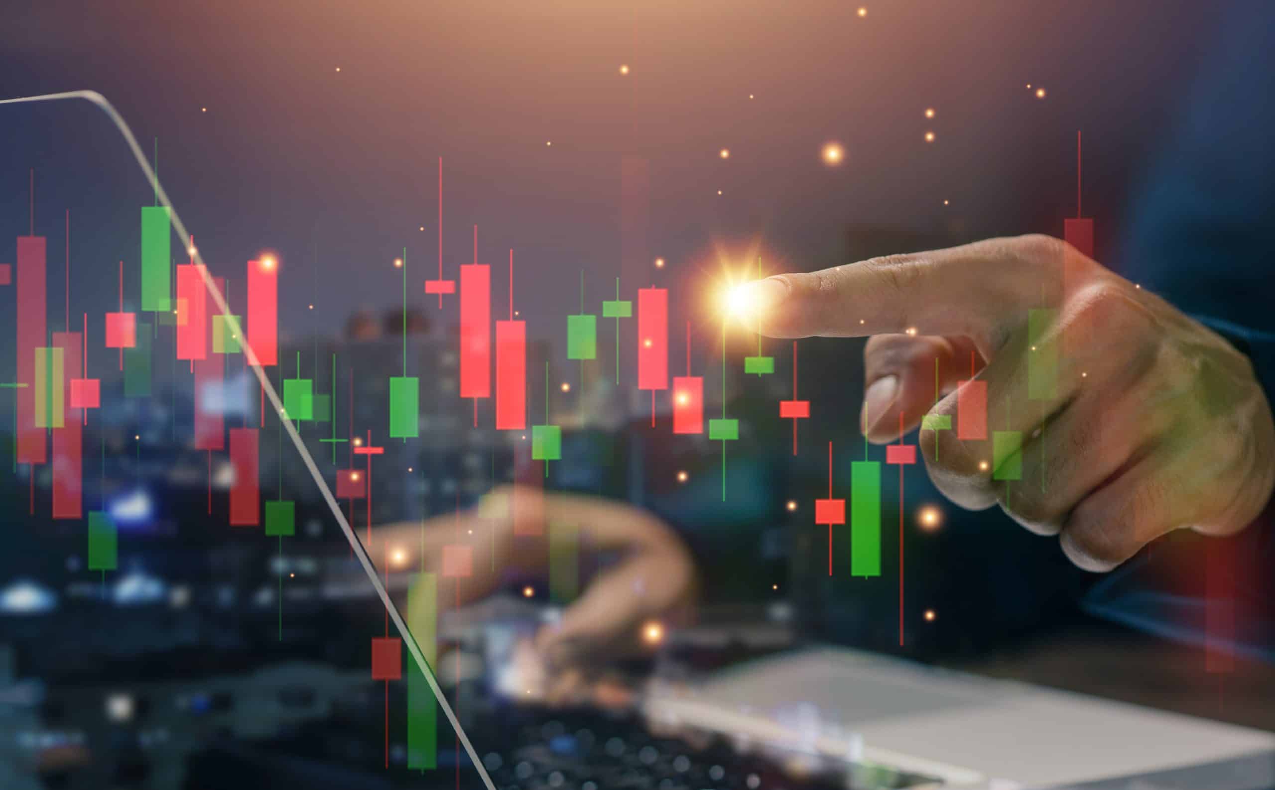 Stock,Trading,Analysis,Concept,With,Investor,Hand,Pointing,At,Candlestick Hand at stockmarket chart, source: Shutterstock